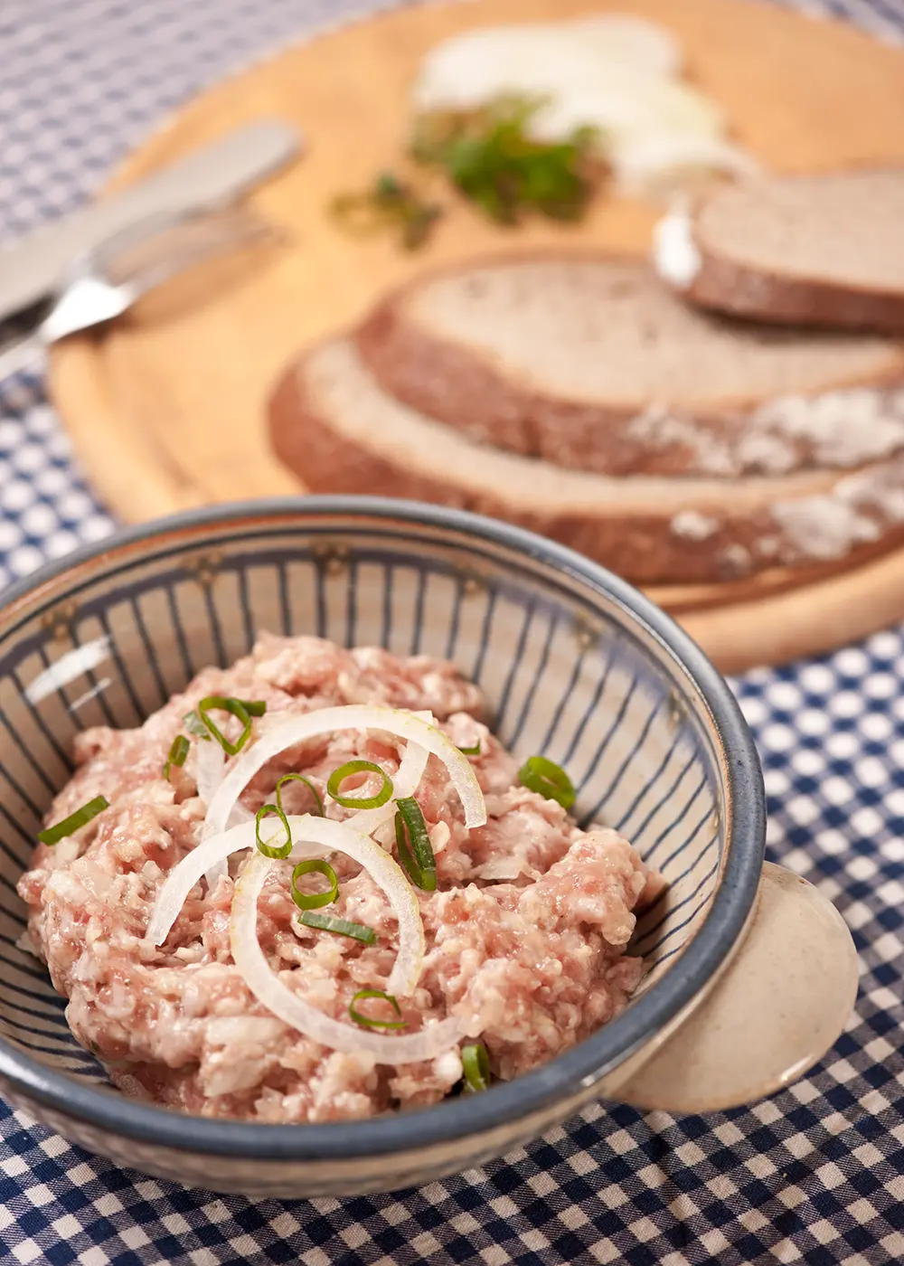 Fränkisches Mett mit Zwiebeln und Bauernbrot auf einer traditionellen Brotzeitplatte.